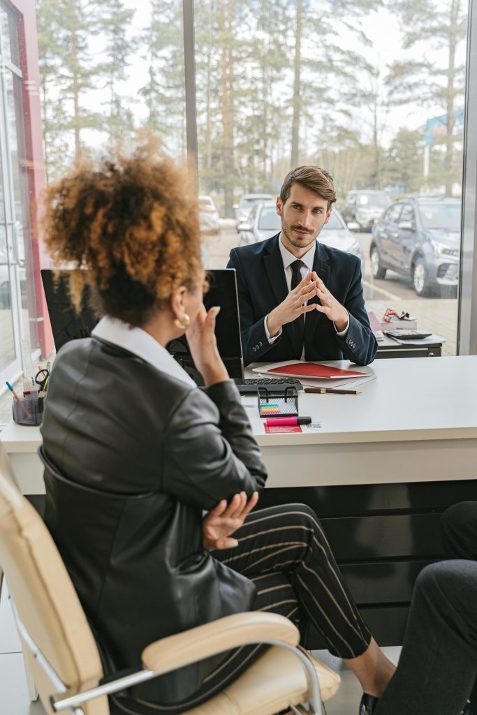 Business professionals engaged in conversation at a modern office desk, discussing ideas and strategies.